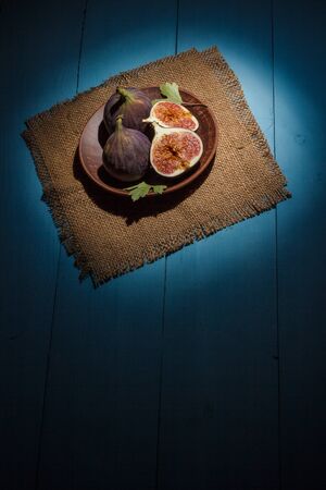 Ripe figs on a blue wooden surfaceの写真素材
