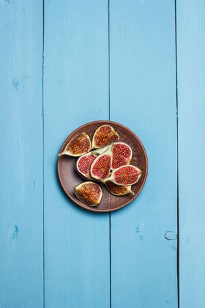 Ripe figs on a blue wooden surfaceの写真素材