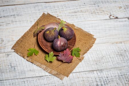 Ripe figs on a white wooden surfaceの写真素材