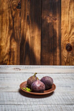 Ripe figs on a white wooden surfaceの写真素材