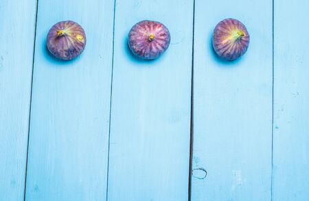 Ripe figs on a blue wooden surfaceの写真素材