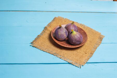 Ripe figs on a blue wooden surfaceの写真素材