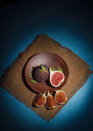 Ripe figs on a blue wooden surfaceの写真素材