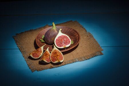 Ripe figs on a blue wooden surfaceの写真素材