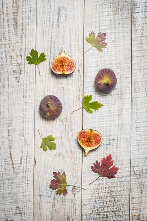 Ripe tasty figs on a white wooden surface.の写真素材