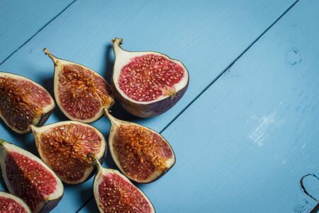 Ripe figs on a blue wooden surfaceの写真素材