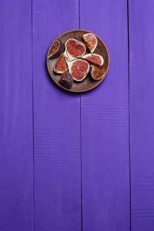 Ripe figs on a purple wooden surfaceの写真素材