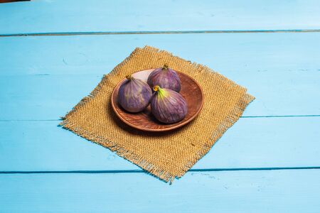 Ripe figs on a blue wooden surfaceの写真素材