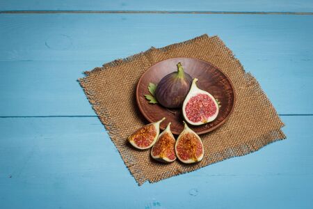 Ripe figs on a blue wooden surfaceの写真素材