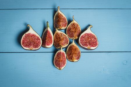 Ripe figs on a blue wooden surfaceの写真素材