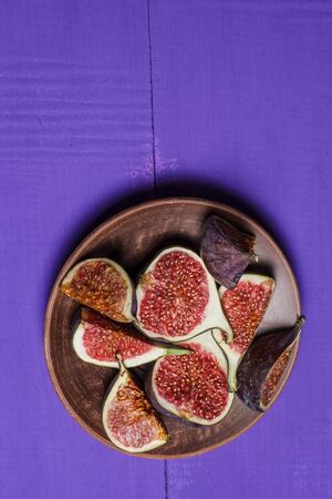 Ripe figs on a purple wooden surfaceの写真素材