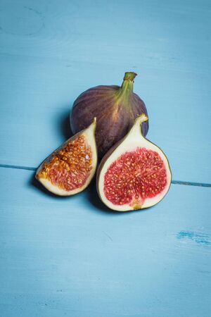 Ripe figs on a blue wooden surfaceの写真素材