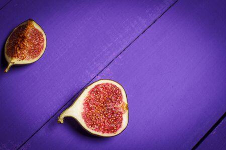 Ripe figs on a purple wooden surfaceの写真素材
