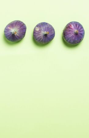 Three ripe figs on a green backgroundの写真素材