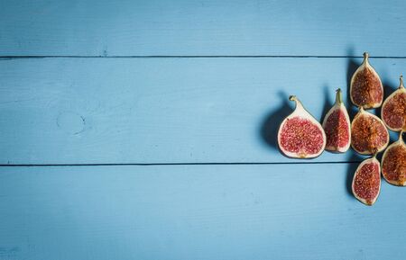 Ripe figs on a blue wooden surfaceの写真素材