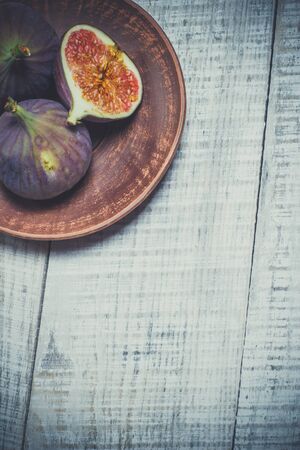 Ripe figs on a white wooden surfaceの写真素材