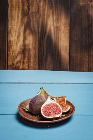 Ripe figs on a blue wooden surfaceの写真素材