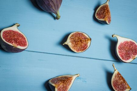 Ripe figs on a blue wooden surfaceの写真素材