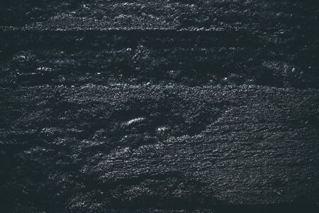 Black resin wall texture with scratches and cracks.の写真素材