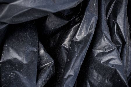 Black plastic crumpled garbage bagの写真素材