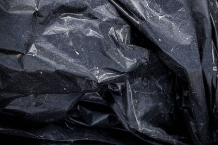 Black plastic crumpled garbage bagの写真素材