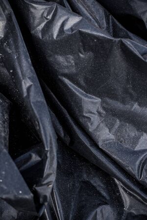 Black plastic crumpled garbage bagの写真素材