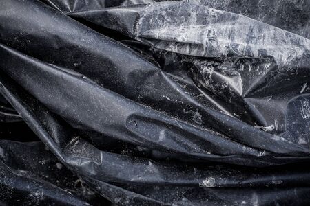 Black plastic crumpled garbage bagの写真素材