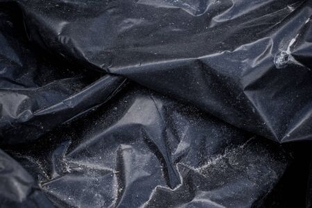 Black plastic crumpled garbage bag