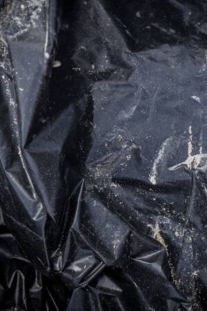 Black plastic crumpled garbage bagの写真素材