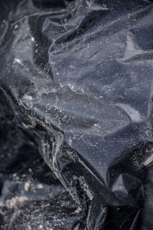 Black plastic crumpled garbage bagの写真素材