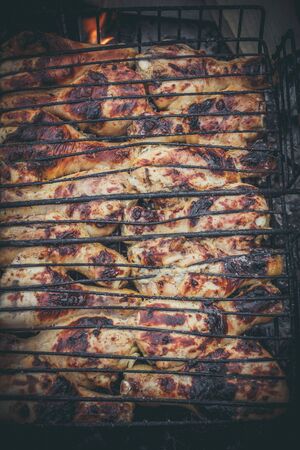 The meat is grilled on a grill with wood and charcoalの写真素材