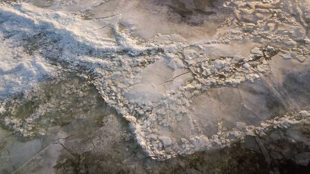 Bid on a frozen river with pieces of ice from a height of flight in the evening