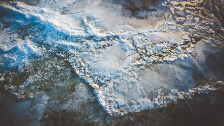 Bid on a frozen river with pieces of ice from a height of flight in the eveningの写真素材