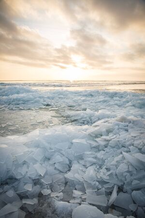 A large number of pieces of ice by the river at sunsetの写真素材