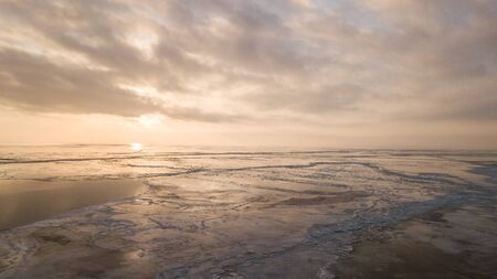 A large number of pieces of ice by the river at sunsetの写真素材