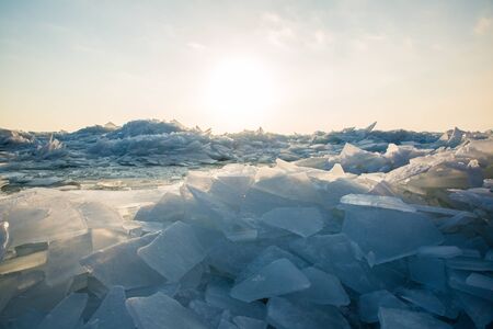 A large number of pieces of ice by the river at sunsetの写真素材