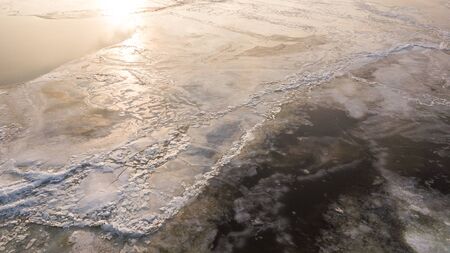 Bid on a frozen river with pieces of ice from a height of flight in the evening