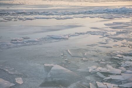 A large number of pieces of ice by the river at sunsetの写真素材