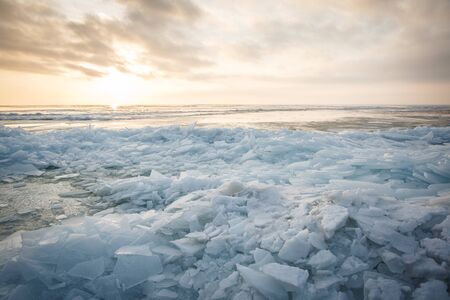 A large number of pieces of ice by the river at sunsetの写真素材