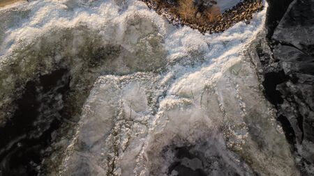 Bid on a frozen river with pieces of ice from a height of flight in the eveningの写真素材