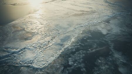 Bid on a frozen river with pieces of ice from a height of flight in the eveningの写真素材