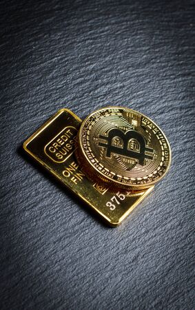 Bitcoins and gold bullion on black background closeの写真素材