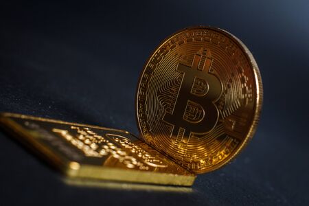 Bitcoins and gold bullion on black background closeの写真素材