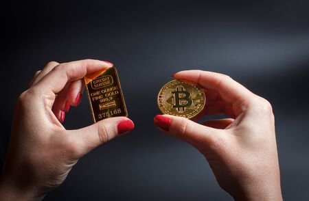 Bitcoins in a girl's hand on a black backgroundの写真素材