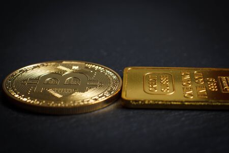 Bitcoins and gold bullion on black background closeの写真素材