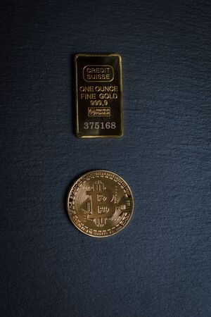 Bitcoins and gold bullion on black background closeの写真素材