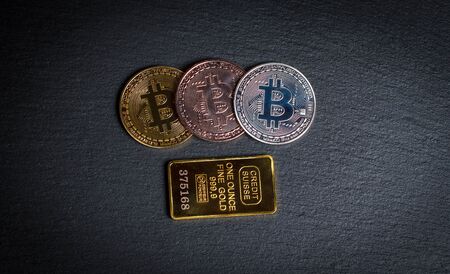 Bitcoins and gold bullion on black background closeの写真素材