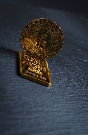 Bitcoins and gold bullion on black background closeの写真素材