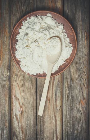 Flour and spikelets of wheat for baking bread lies on a wooden brown surfaceの写真素材