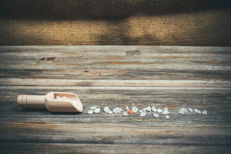 Different spices and salt lie in wooden spoons on a wooden brown tableの写真素材